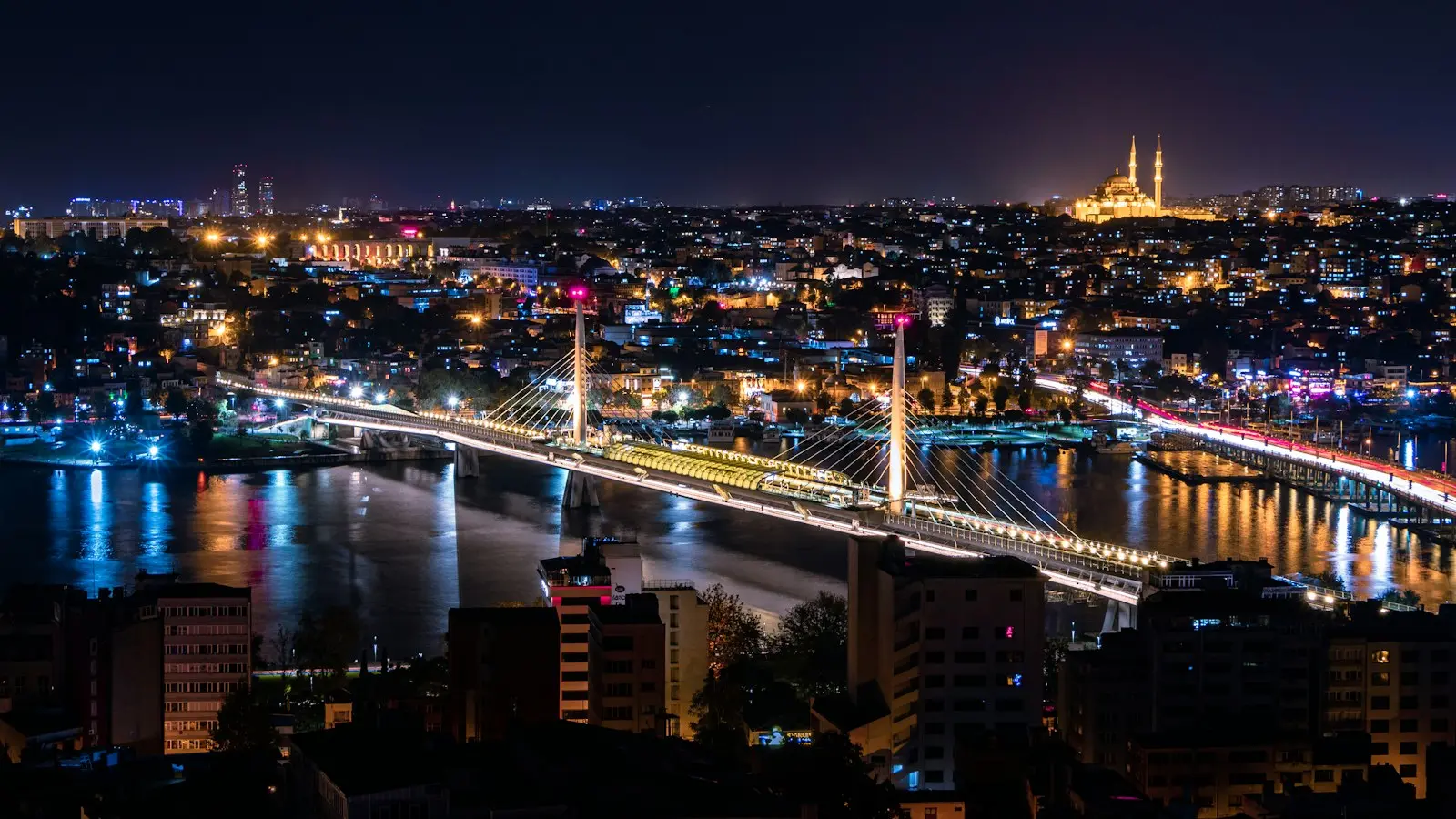 Gece İstanbul’da Haliç üzerindeki köprüler ve ışıklı tarihi yarımada silueti