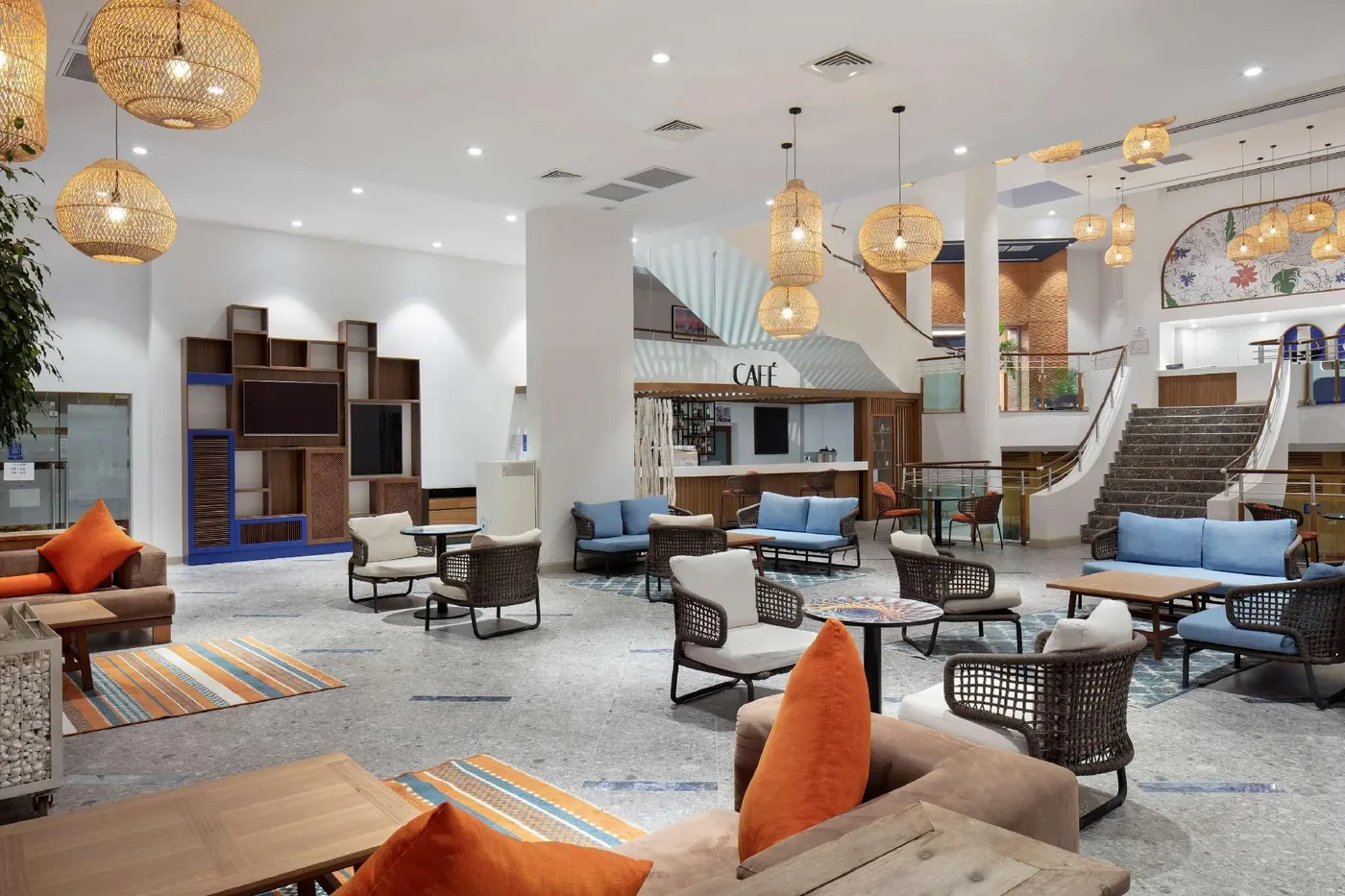 DoubleTree by Hilton Bodrum Işıl Club lobisi: rattan sarkıt lambalar, turuncu minderli koltuklar ve farklı oturma grupları